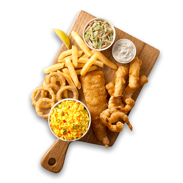 Fish, rice and chips with tartare sauce and coleslaw salad on a wooden boaard
